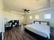 Bright bedroom with hardwood floors, ceiling fan, a desk, shelving, and a door leading to a hallway at 3508 Harbor Tides St, Las Vegas, NV 89147