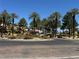 Beautiful neighborhood entrance featuring lush landscaping, mature trees, and a charming guard house in a desirable community at 3508 Harbor Tides St, Las Vegas, NV 89147