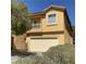Two story tan home featuring a two car garage and balcony at 3508 Harbor Tides St, Las Vegas, NV 89147