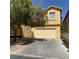 Two story tan home featuring a two car garage and balcony at 3508 Harbor Tides St, Las Vegas, NV 89147