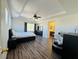 Spacious main bedroom with hardwood floors, a ceiling fan, ensuite bath, and natural light from large windows at 3508 Harbor Tides St, Las Vegas, NV 89147