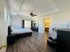 Spacious main bedroom with hardwood floors, a ceiling fan, ensuite bath, and natural light from large windows at 3508 Harbor Tides St, Las Vegas, NV 89147