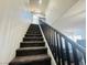 Carpeted staircase with a dark railing leading up to the upper level of the home at 3508 Harbor Tides St, Las Vegas, NV 89147