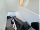 Carpeted staircase with dark wood railing leads to a lower level with wood-look floors and white walls at 3508 Harbor Tides St, Las Vegas, NV 89147