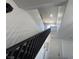 A staircase with carpeted steps and a dark railing leads to the upper level of this home at 3508 Harbor Tides St, Las Vegas, NV 89147
