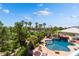 A lush backyard with a luxurious pool, spa, rock waterfall, and scenic golf course views at 352 Angels Trace Ct, Las Vegas, NV 89148