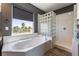 A luxurious bathroom features a large soaking tub, glass block window, and a separate glass enclosed shower at 352 Angels Trace Ct, Las Vegas, NV 89148