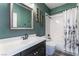 Green bathroom featuring a modern vanity, mirror and bathtub with shower at 352 Angels Trace Ct, Las Vegas, NV 89148