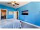Blue bedroom with mounted TV, plush carpeting, and great lighting at 352 Angels Trace Ct, Las Vegas, NV 89148