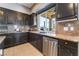 Well-lit kitchen featuring dark wood cabinets, stainless steel appliances, and a window over the sink at 352 Angels Trace Ct, Las Vegas, NV 89148