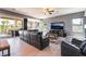 Spacious living room with a leather sectional sofa, fireplace, and sliding glass doors to an outdoor patio at 352 Angels Trace Ct, Las Vegas, NV 89148