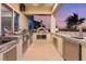 Fully equipped outdoor kitchen with a pizza oven, stainless steel appliances, and ample counter space for preparing meals at 352 Angels Trace Ct, Las Vegas, NV 89148