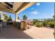 Outdoor kitchen with built-in grill, pizza oven, bar, and comfortable seating area at 352 Angels Trace Ct, Las Vegas, NV 89148