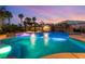 Large pool features a waterfall, a cabana with outdoor seating, and lush tropical landscaping at 352 Angels Trace Ct, Las Vegas, NV 89148