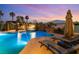 Resort-style pool with a cascading waterfall, comfortable lounge chairs, and lush landscaping at 352 Angels Trace Ct, Las Vegas, NV 89148