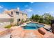 A luxurious backyard pool surrounded by lush landscaping and a beautiful home exterior at 352 Angels Trace Ct, Las Vegas, NV 89148