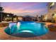 Luxurious backyard pool featuring a waterfall, covered dining area, and lush tropical landscaping at 352 Angels Trace Ct, Las Vegas, NV 89148