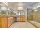 Bathroom with double sinks, spacious granite countertop, wood cabinets, and glass-enclosed shower at 368 Calabria Beach St, Henderson, NV 89015