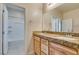 Bathroom featuring double vanity with granite counters, wood cabinets, tub, and tile floors at 368 Calabria Beach St, Henderson, NV 89015