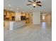 Open-concept kitchen and living area featuring wood cabinets, granite countertops, and light tile flooring at 368 Calabria Beach St, Henderson, NV 89015