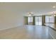 Bright living room with light tile flooring, ceiling fan, large windows, and access to the backyard at 368 Calabria Beach St, Henderson, NV 89015