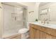 Stylishly renovated bathroom features a glass-enclosed shower and wood vanity with marble-look top at 3748 Silent Hill Dr, Las Vegas, NV 89147