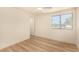 Sunlit bedroom with wood flooring, ceiling fan, and large window with exterior view at 3748 Silent Hill Dr, Las Vegas, NV 89147
