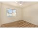 Bright bedroom featuring sleek wood flooring, a ceiling fan, and a sunlit window overlooking the outdoor pool at 3748 Silent Hill Dr, Las Vegas, NV 89147