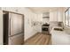 Modern kitchen featuring white cabinets, stainless steel appliances, tile backsplash, and wood flooring at 3748 Silent Hill Dr, Las Vegas, NV 89147