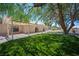 Expansive backyard featuring a covered patio, artificial turf, and mature trees at 3790 W Moberly Ave, Las Vegas, NV 89139