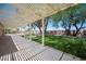 Large backyard with a covered patio, mature trees, and lush green lawn at 3790 W Moberly Ave, Las Vegas, NV 89139