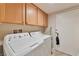 Functional laundry room with overhead storage and white front load washer and dryer at 3975 N Hualapai Way # 121, Las Vegas, NV 89129