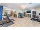 Spacious living area featuring tile flooring, ceiling fan, workout area, and home office setup at 409 Antelope Way, Las Vegas, NV 89145