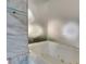A luxurious soaking tub with jets is encased with marble tiles and a frosted privacy window at 4381 Flamingo Rd # 2010, Las Vegas, NV 89103