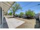 Serene backyard featuring a concrete patio area, mature trees, and a block wall for privacy at 4424 Sunrise Ave, Las Vegas, NV 89110