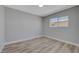 This bedroom boasts light wood-look floors, base trim, and a window at 4424 Sunrise Ave, Las Vegas, NV 89110