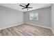 A serene bedroom with light wood-look flooring, a ceiling fan, and a bright window at 4424 Sunrise Ave, Las Vegas, NV 89110