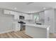 Modern kitchen features white cabinets, stainless steel appliances, and a center island with quartz countertop at 4424 Sunrise Ave, Las Vegas, NV 89110
