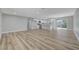 Open-concept living area featuring durable, light-toned wood flooring and views into the modern, white kitchen at 4424 Sunrise Ave, Las Vegas, NV 89110