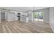 Spacious open-concept living area with wood-look floors and modern, white kitchen at 4424 Sunrise Ave, Las Vegas, NV 89110