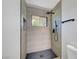Modern walk-in shower with gray tiling, rainfall shower head and sleek fixtures at 4424 Sunrise Ave, Las Vegas, NV 89110
