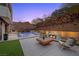 An outdoor living area featuring a pool, fireplace, desert landscaping, and patio furniture at 5 Highland Cove Ln, Henderson, NV 89011