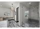 Modern bathroom featuring an open vanity, decorative mirror, and glass enclosed shower with tiled walls and floors at 5 Highland Cove Ln, Henderson, NV 89011