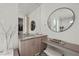 Bathroom with vanity, round mirror, and open closet with shelf and hanging clothes at 5 Highland Cove Ln, Henderson, NV 89011