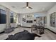 Open floor plan with fireplace, light floors, geometric mirror and multiple windows at 5 Highland Cove Ln, Henderson, NV 89011