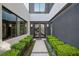 Inviting entryway with manicured hedges leading to a modern double door entrance and staircase beyond at 5 Highland Cove Ln, Henderson, NV 89011