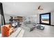 Bright open living area featuring a gray sectional sofa, an orange chair, and sliding glass doors with mountain views at 5 Highland Cove Ln, Henderson, NV 89011