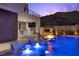 Modern outdoor living with a pool, bar, grill, and lounge area, illuminated for evening enjoyment at 5 Highland Cove Ln, Henderson, NV 89011