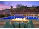 Backyard pool area with fire feature, beanbag chairs, hillside views, and rock wall with waterfall feature at 5 Highland Cove Ln, Henderson, NV 89011