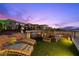 Relaxing rooftop deck area featuring comfortable lounge chairs, an outdoor kitchen, and stunning mountain views at 5 Highland Cove Ln, Henderson, NV 89011
